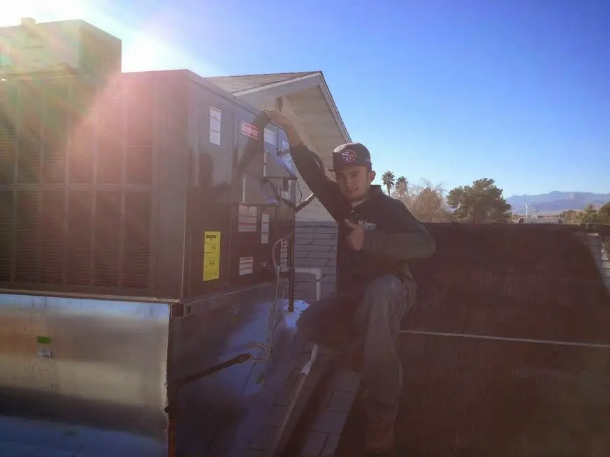 HVAC technician performing Air Duct Cleaning on a rooftop unit in Hadley